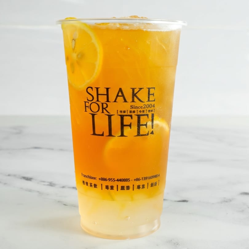 A Shake For Life! iced lemon tea with lemon slices and ice in a clear cup.