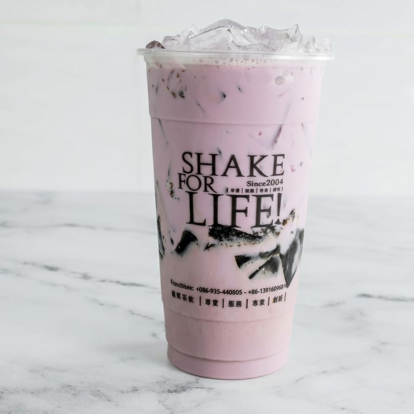 A Shake For Life! bubble tea with purple liquid, dark jelly, and ice on a marble surface.