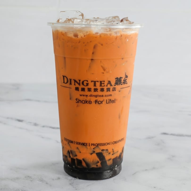 A Ding Tea Thai Iced Tea with ice and dark jelly on a white marble surface.